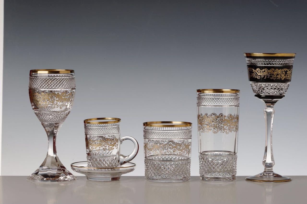 Hand-cut crystal collection with gold ornament in an elegant banquet setting